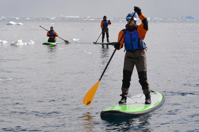 sleeping in antarctica - image of woman paddleboarding in antarctica