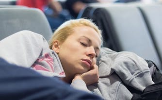 image of woman sleeping in airport while traveling