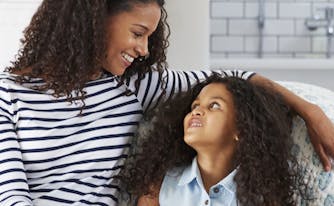 image of mom and child sitting on floor next to bed