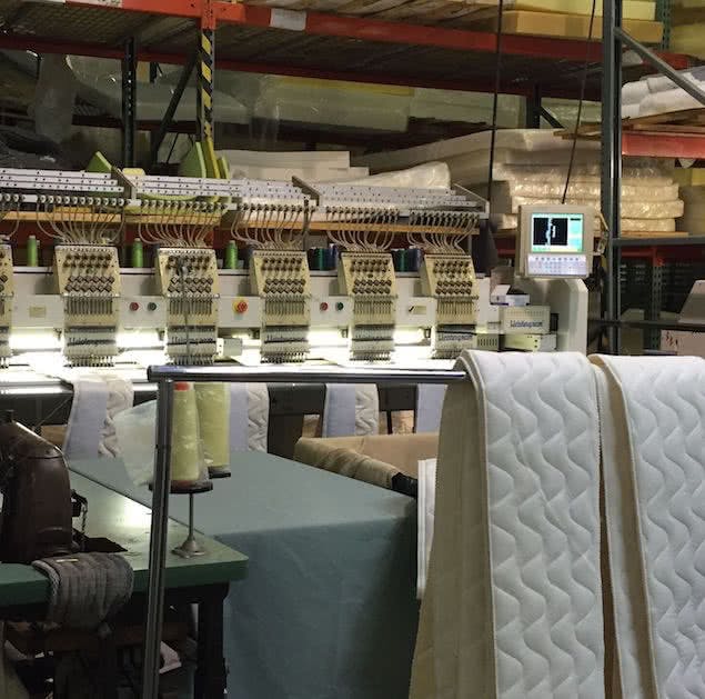 saatva mattress factory with sewing station and fabric panels