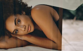 image of person lying on top of sheets on bed