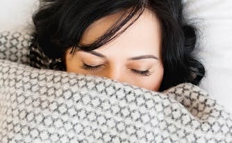 image of woman wrapped in weighted blanket