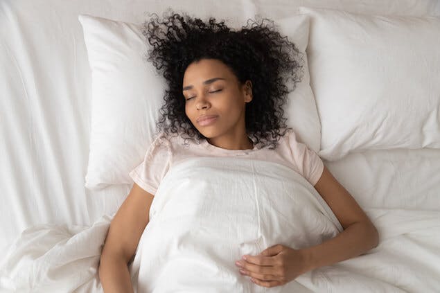 how to sleep with lower back pain - person lying on back