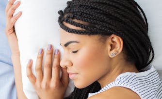 best pillow for health - image of person hugging pillow in bed