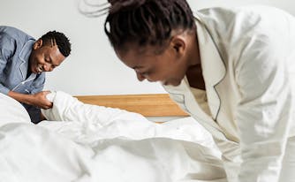 image of woman making bed in the morning