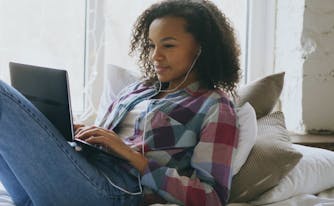 image of person video chatting with friends from bed