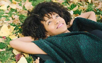 image of woman lying in grass in fall - change of seasons and sleep