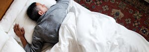 best mattress for stomach sleepers - image of man sleeping on stomach