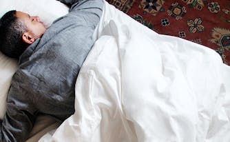 best mattress for stomach sleepers - image of man sleeping on stomach