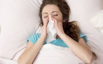 image of person with allergies in bed