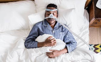 image of man with sleep apnea wearing CPAP machine