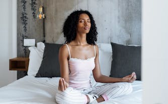 image of person meditating on bed to get rid of sunday scaries