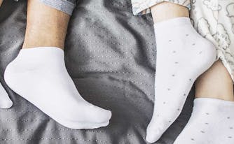 image of feet sticking out of bed - top sheet tucked vs untucked