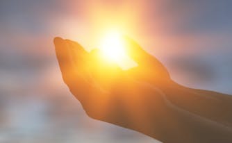 image of person holding out hands in the sun