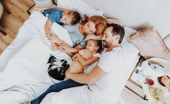 family sleeping in biggest bed size