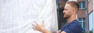 two people storing a mattress in a moving truck