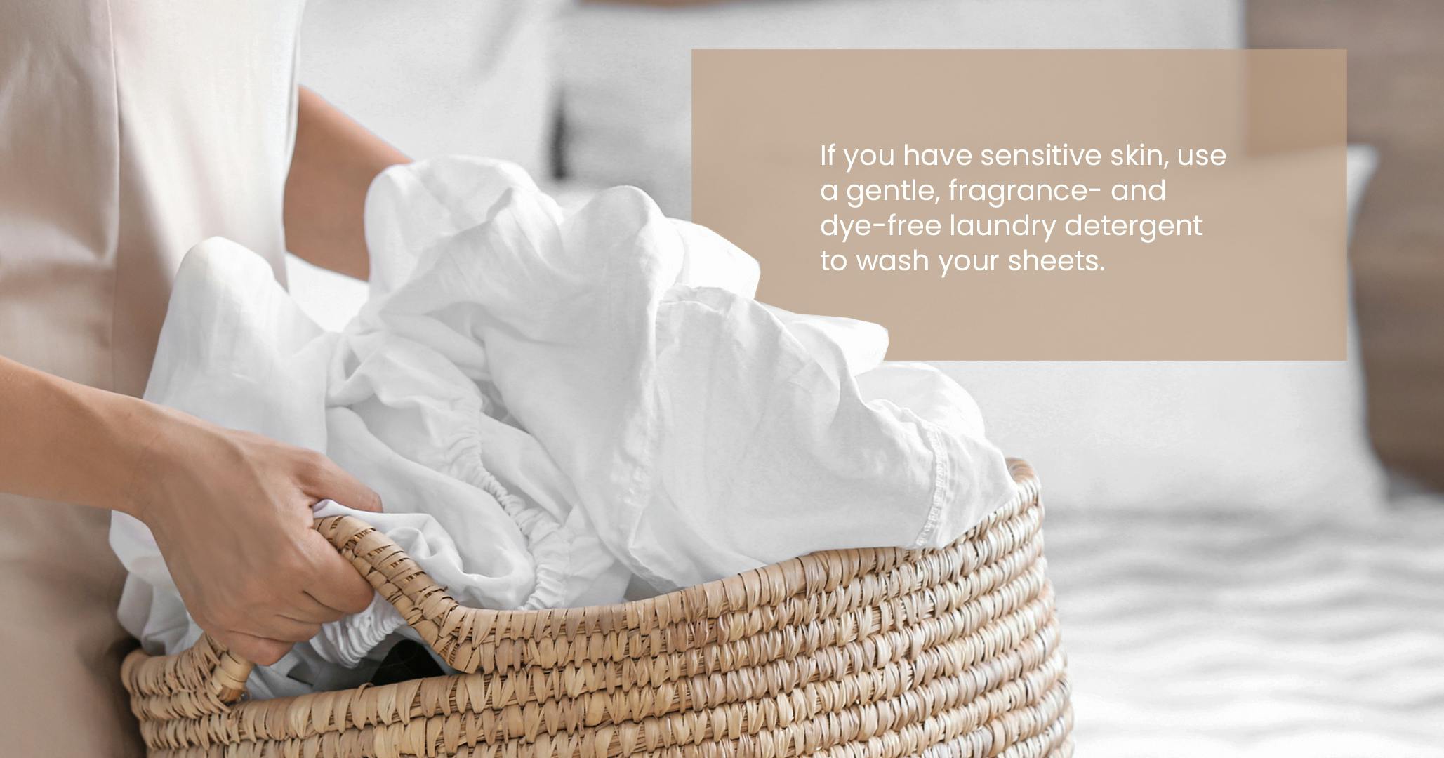 person holding laundry basket of sheets with description of how to wash sheets when you have sensitive skin
