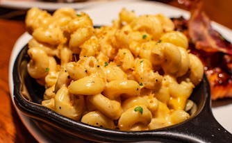 macaroni in a skillet and bacon on plate