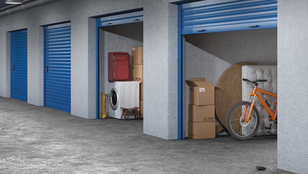 storage unit with a mattress, bicycle, table, and boxes in it