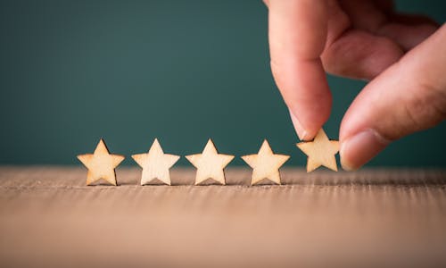 Hand arranging five stars in a row. A picture describing for Saatva's five-star customer service experience.