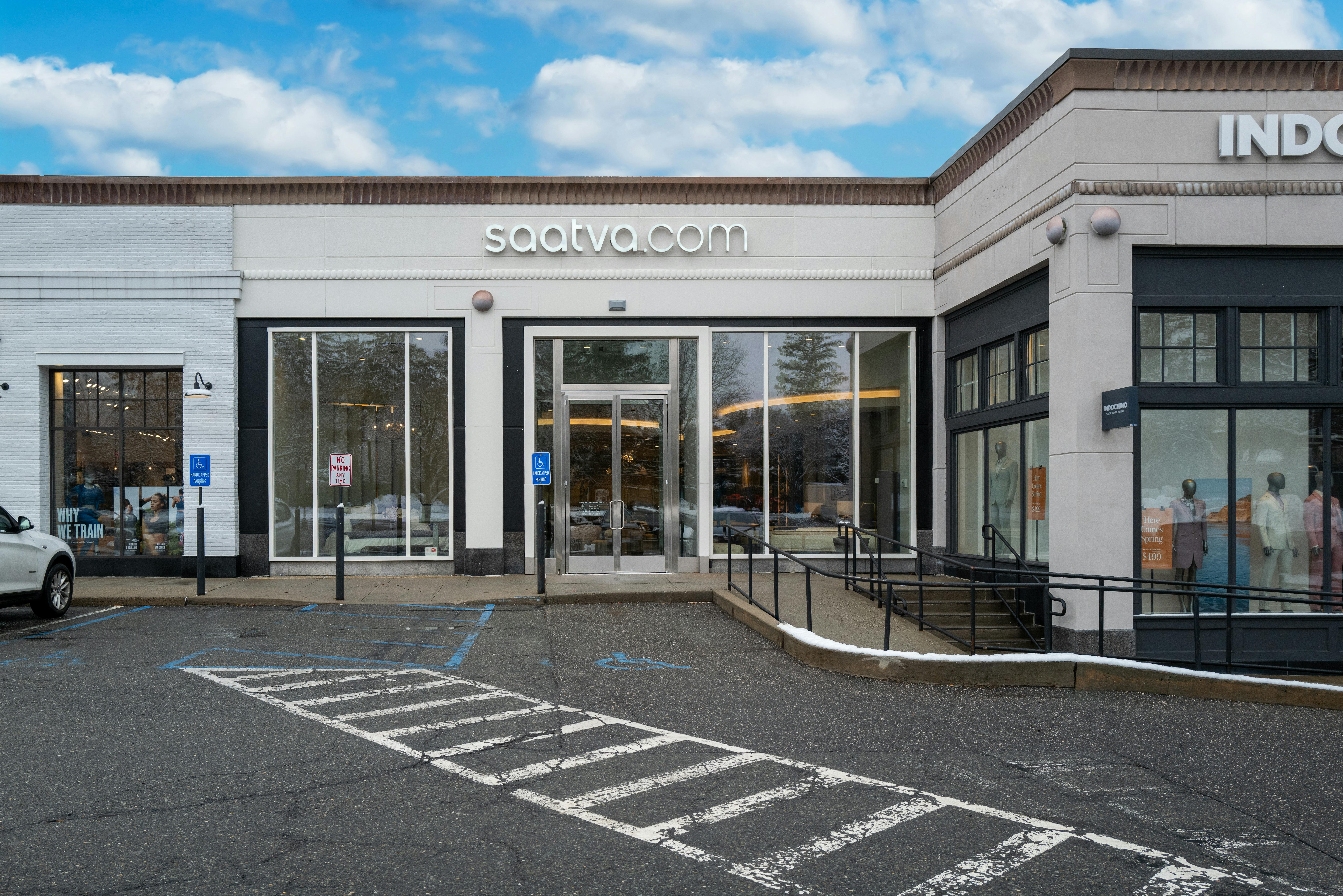The stunning, bright exterior of the Saatva Manhasset retail location and curbside parking lot. 