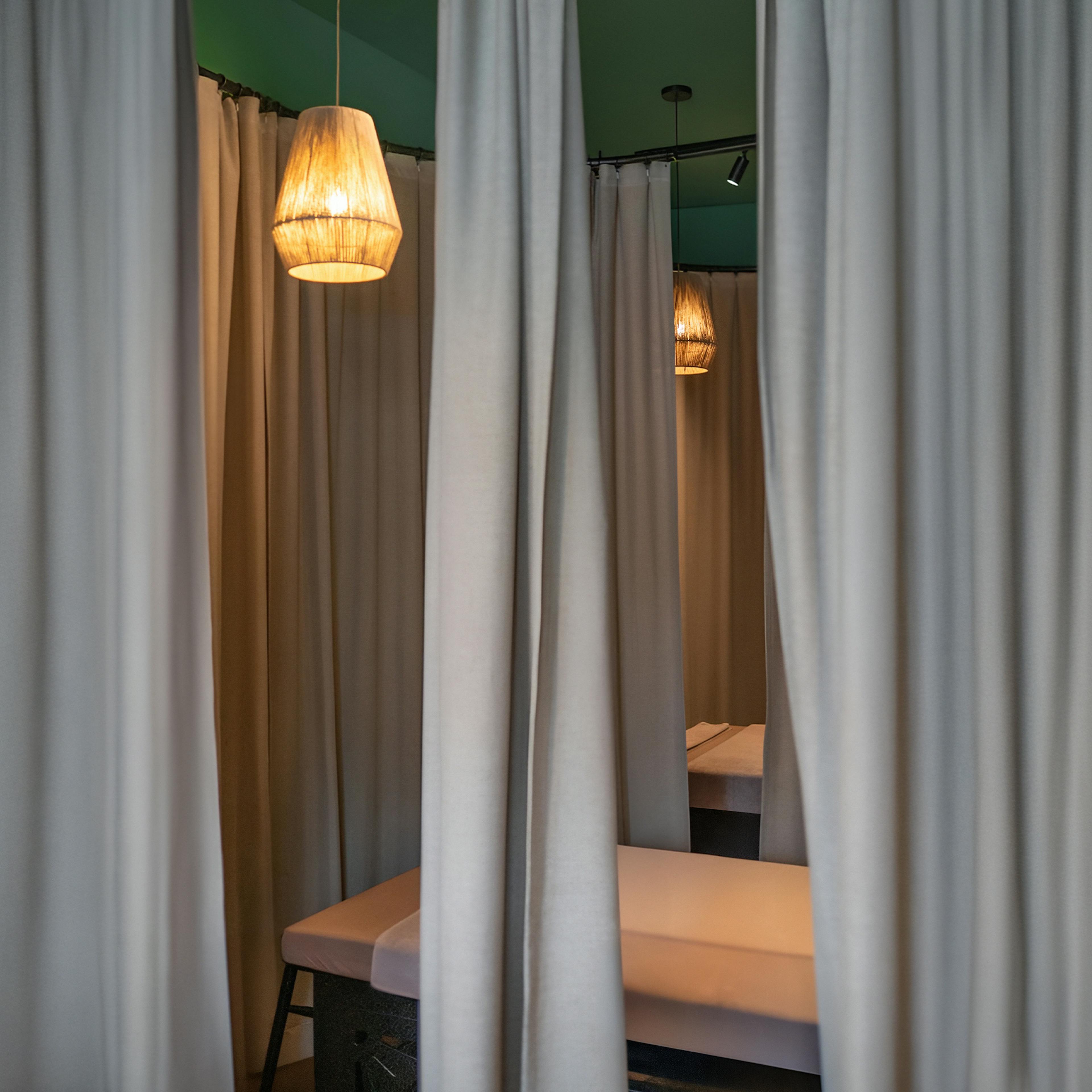 A corner of the studio with soft curtains and a hanging lamp — peaceful interior at Sabai Sabai.