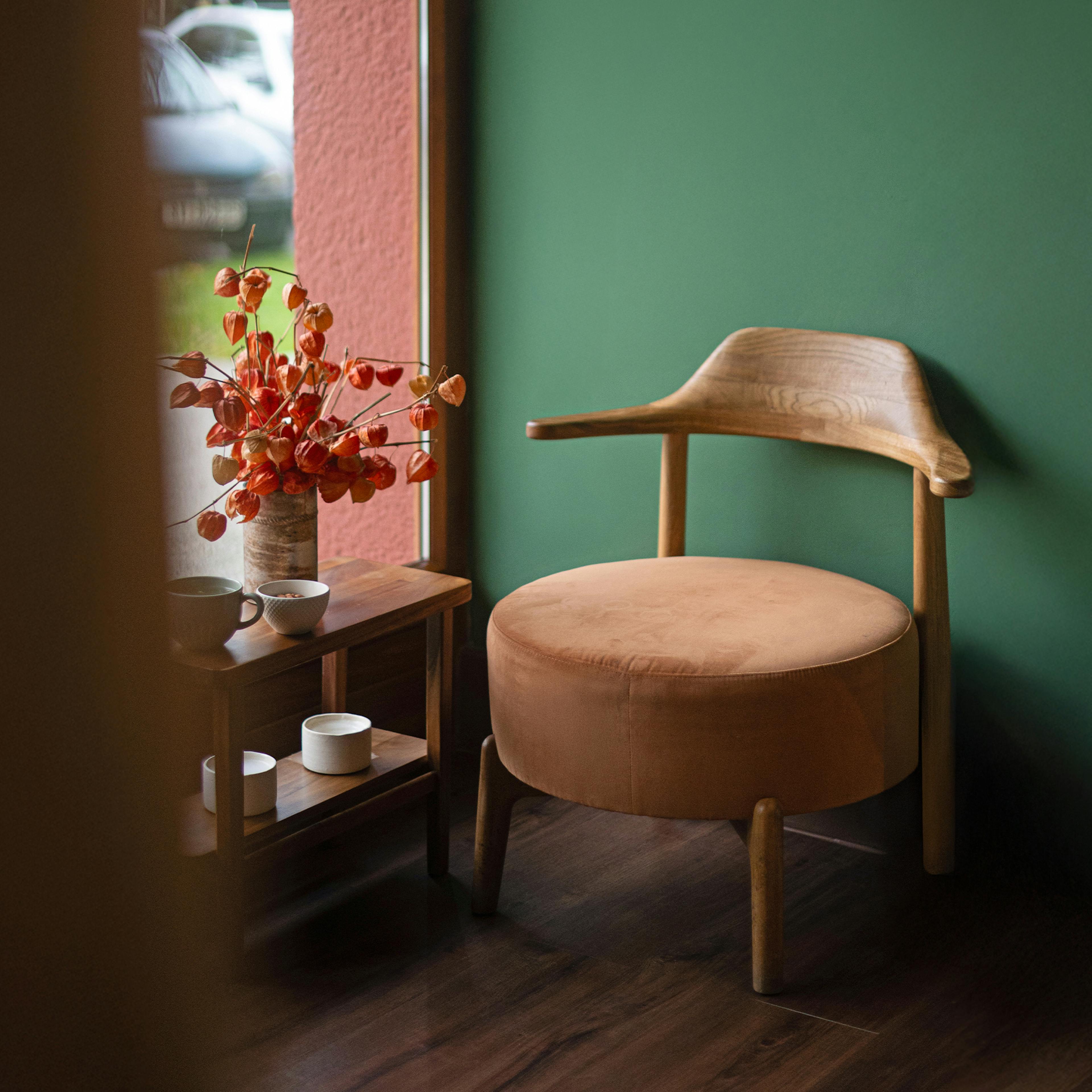 A comfortable wooden lounge chair by the window - a resting spot in Sabai Sabai’s calm interior.