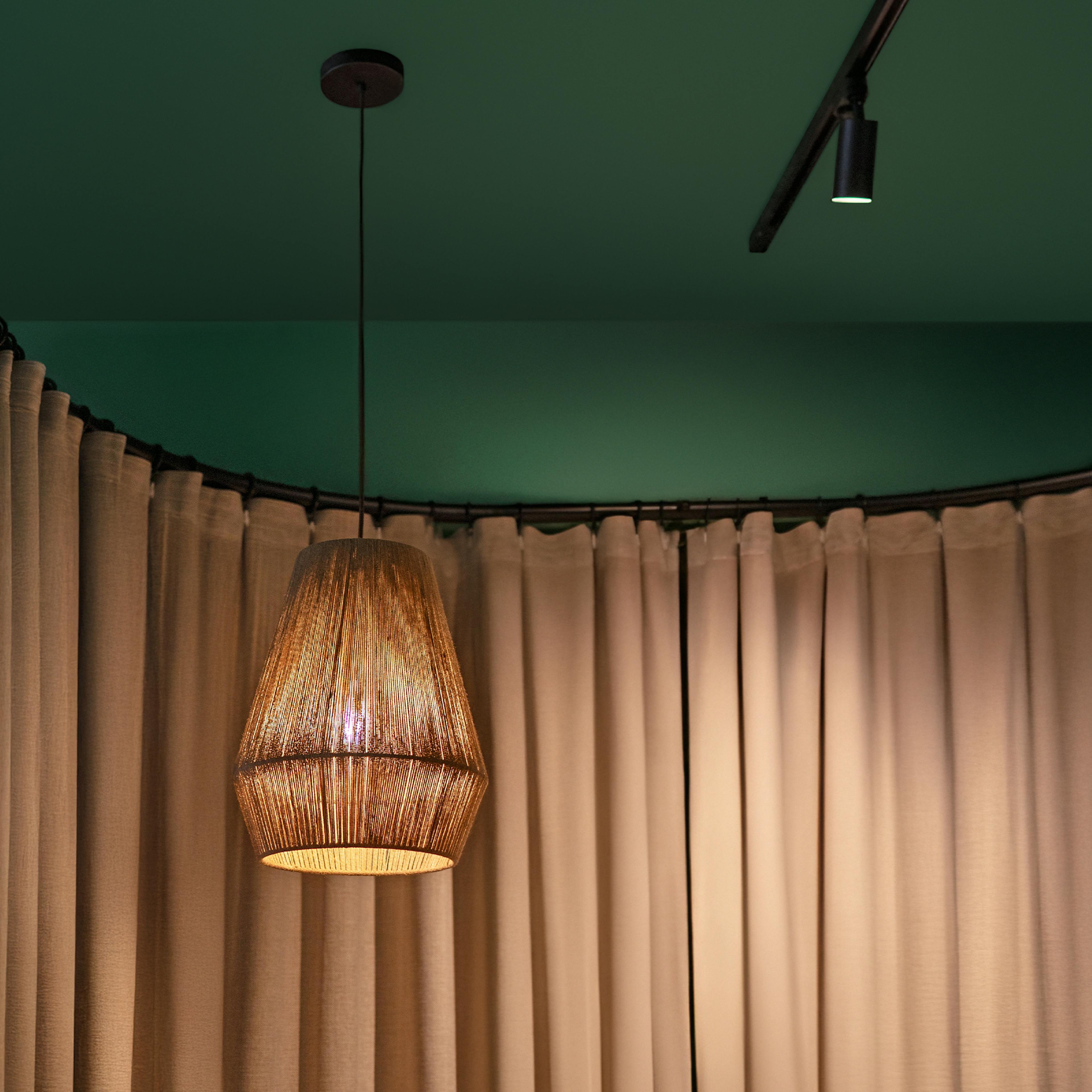 A corner of the studio with soft curtains and a hanging lamp — peaceful interior at Sabai Sabai.