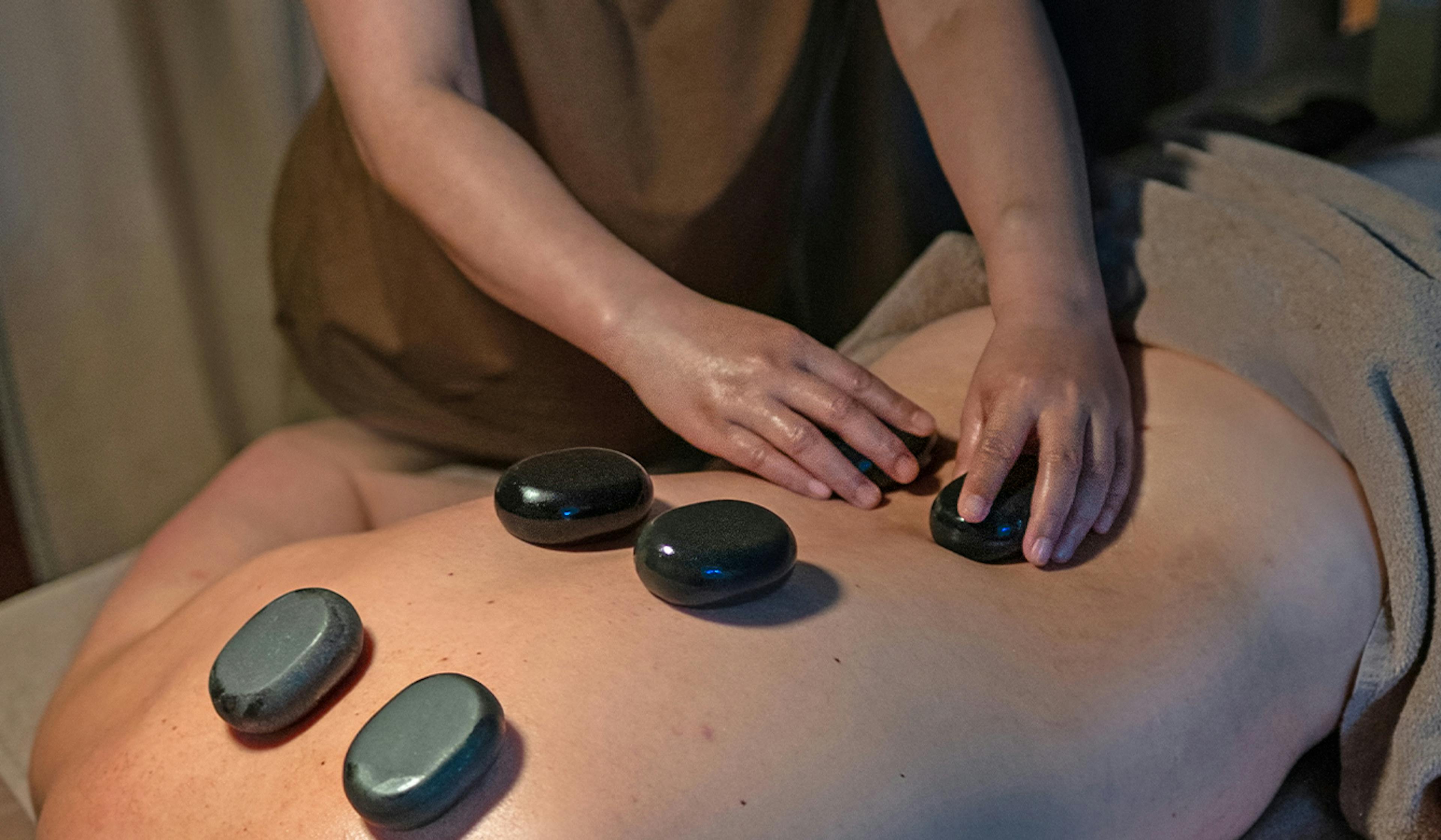 Smooth basalt stones placed along the spine during Thai Hot Stone Massage at Sabai Sabai Split — a treatment for deep relaxation and energy restoration.