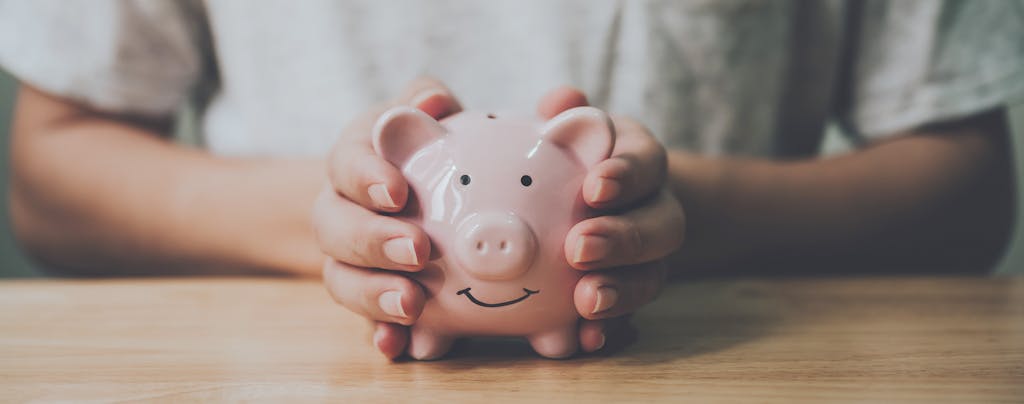 Man's hands holding a  piggy bank