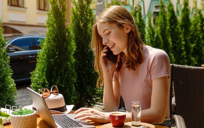 Woman speaking through the phone and working outdoors