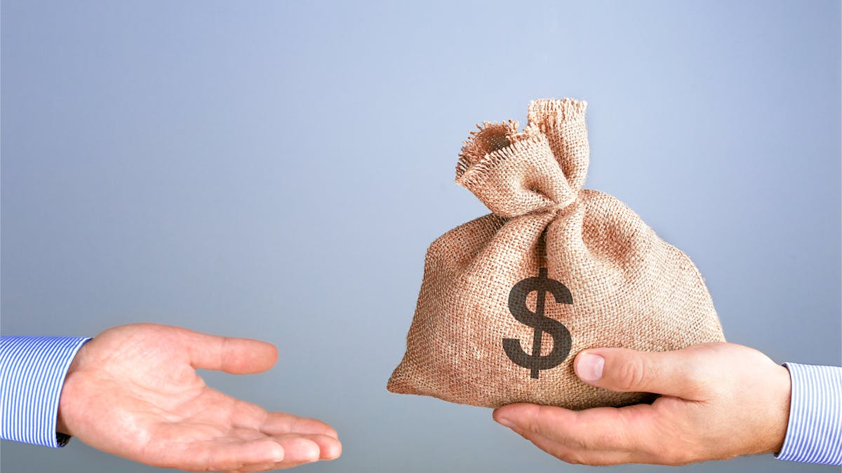 Man holds, gives a bag of money in hand like a bonus.