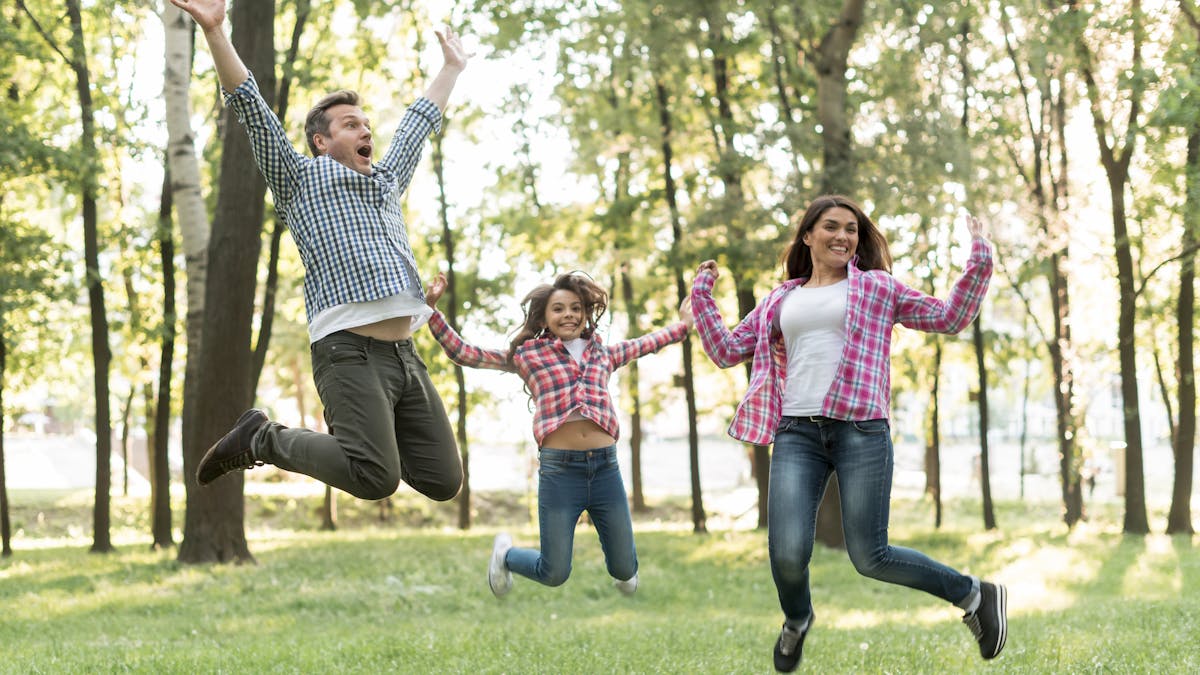 Happy family jumping in green nature <a href='https://www.freepik.com/photos/tree'>Tree photo created by freepik - www.freepik.com</a>