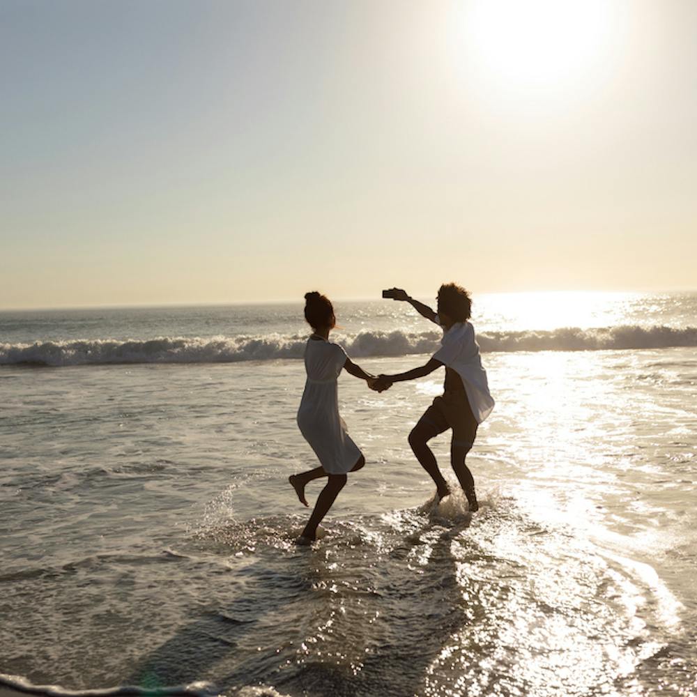 Photo of a couple having fun while dancing together on the beach <a href="https://www.freepik.com/free-photo/couple-having-fun-while-taking-selfie-with-mobile-phone-beach_5195151.htm#query=free%20happy%20beach&position=18&from_view=search&track=ais">Image by wavebreakmedia_micro</a> on Freepik