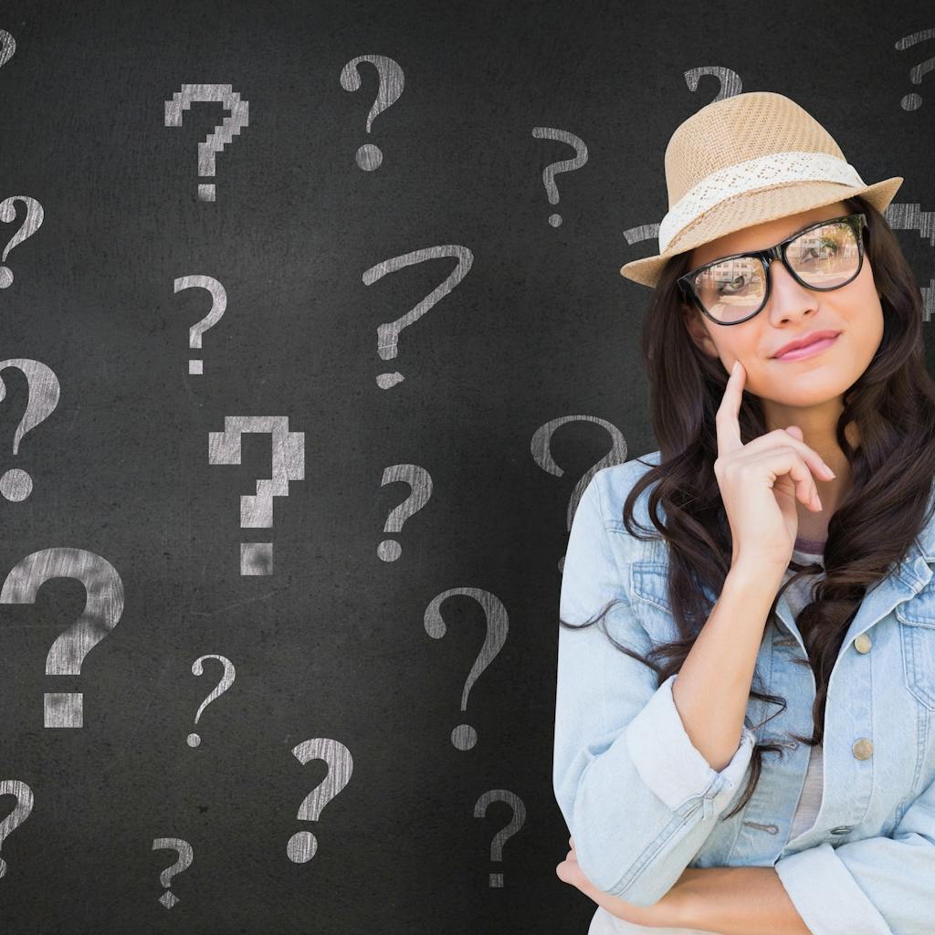 Woman in front of a black board with questions marks