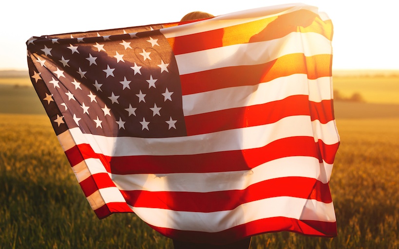A woman carrying a USA flag