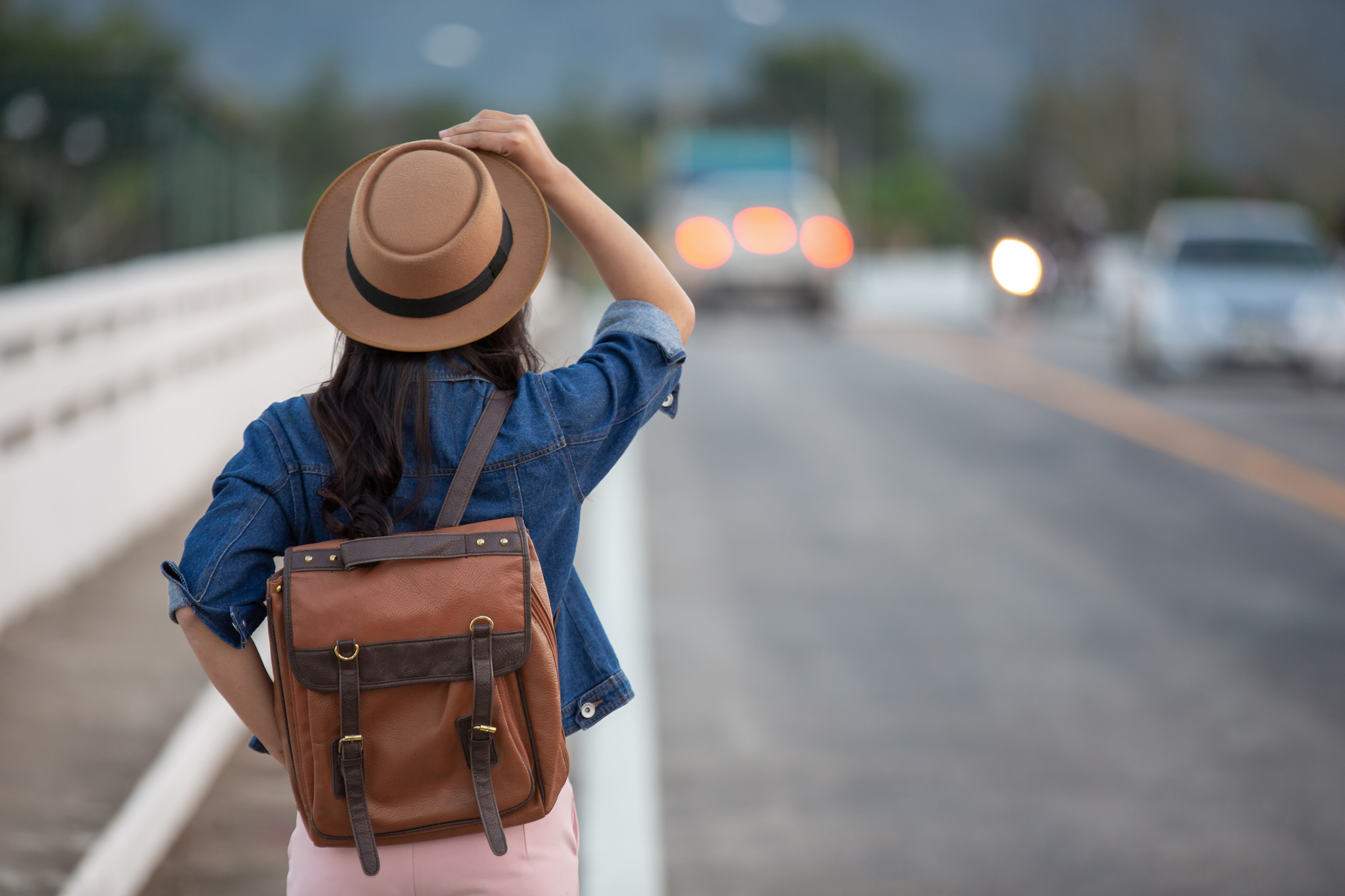 Girl traveling with a backpack in a road