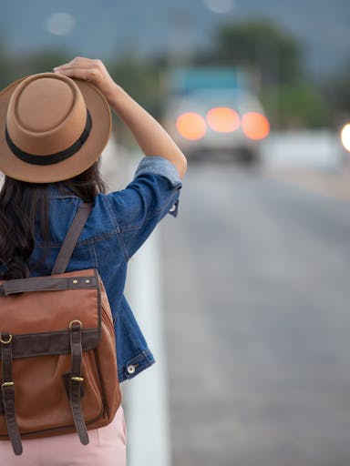 Girl traveling with a backpack in a road