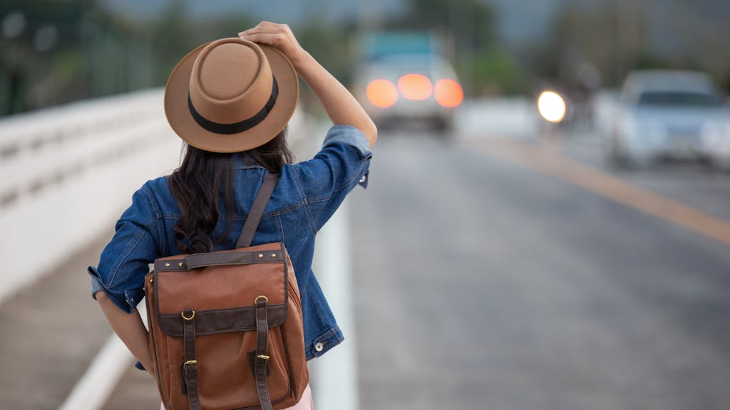 Girl traveling with a backpack in a road