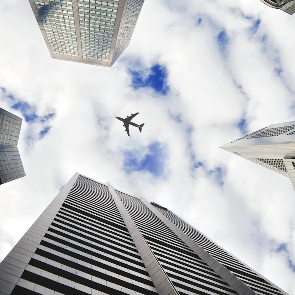 Airplane flying over skyscrapers