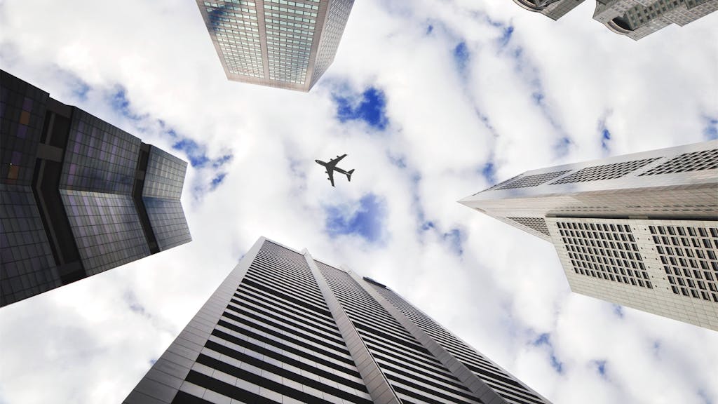 Airplane flying over skyscrapers