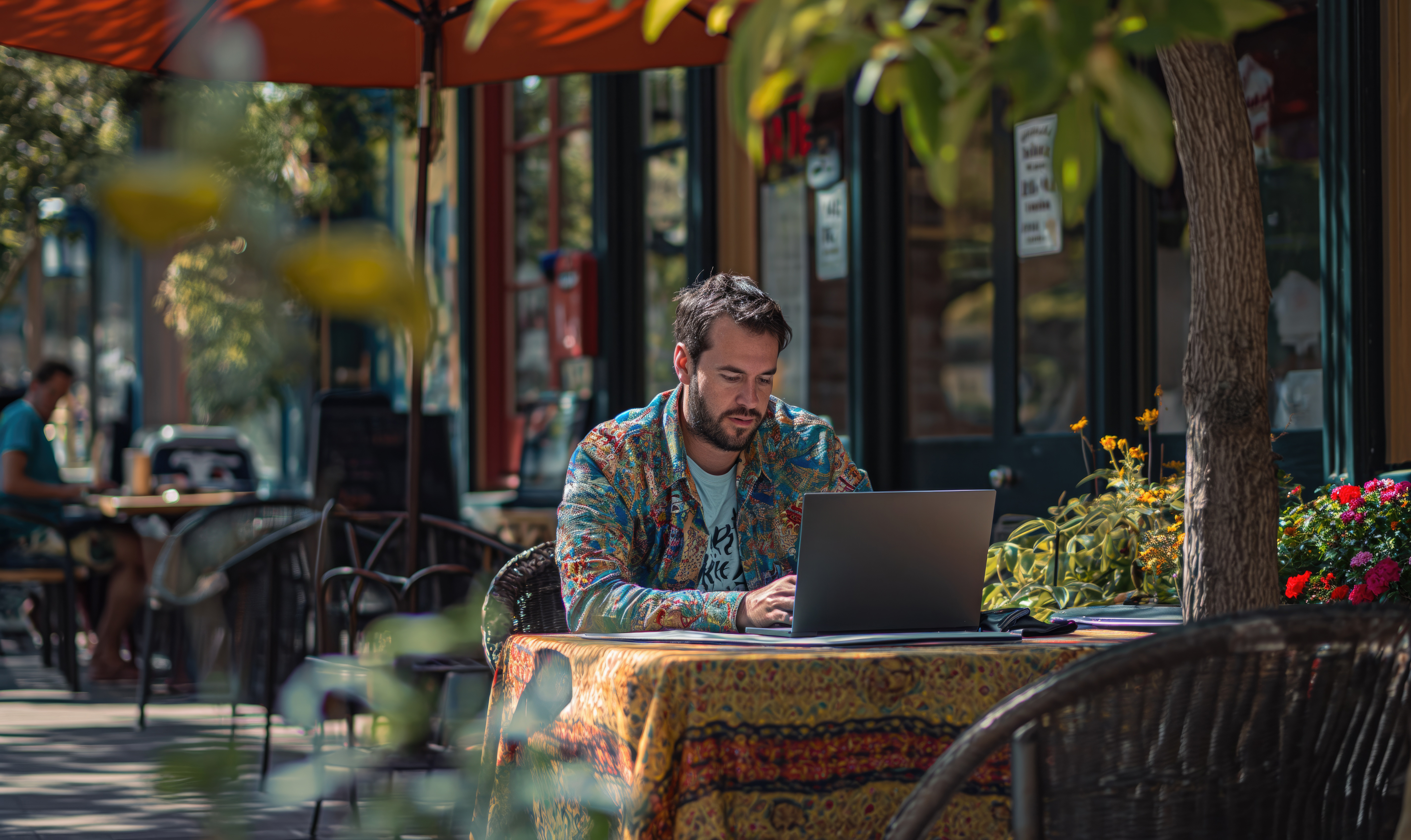 Man working on his laptop in a acfe terrace.