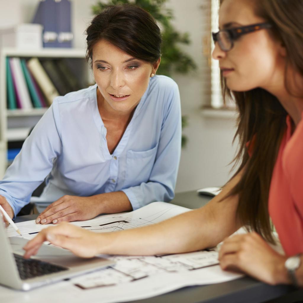Two women consulting data on the computer