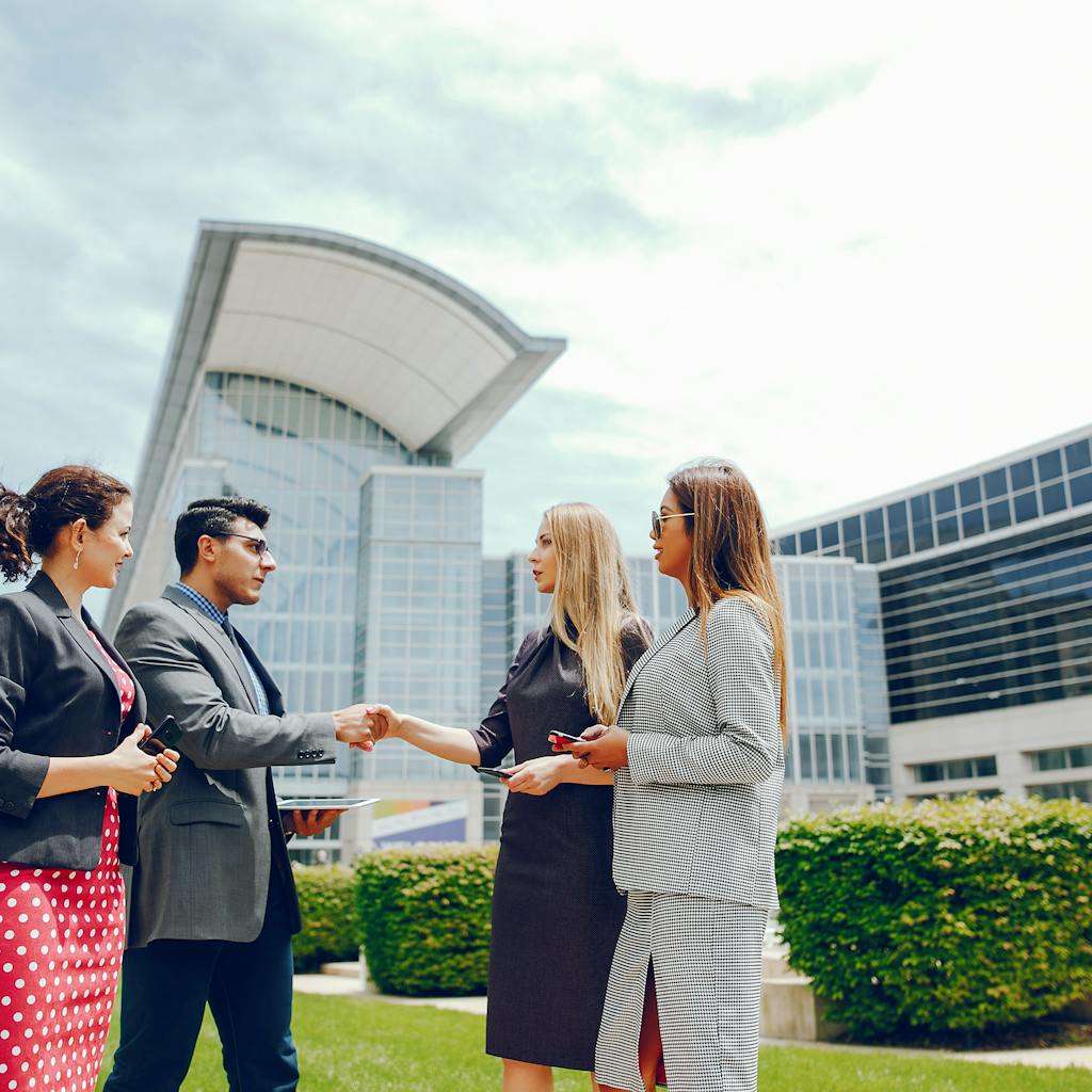 A businessman with  three businesswomen in a city during the summer