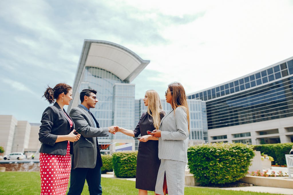 A businessman with  three businesswomen in a city during the summer