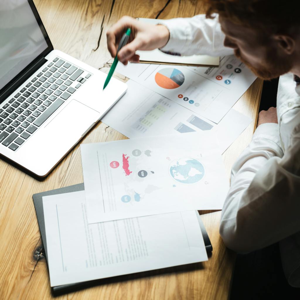 Top view of young successful businessman in white shirt working on wooden table