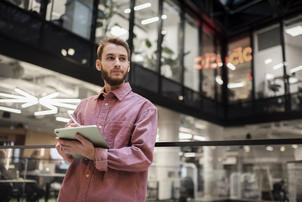 Business Owner standing  in his office while holding his tablet