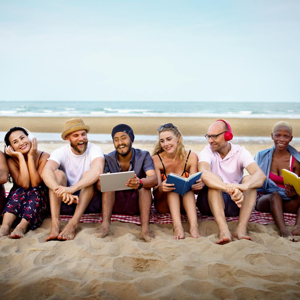 Group of young friend working and smiling together at the beach
