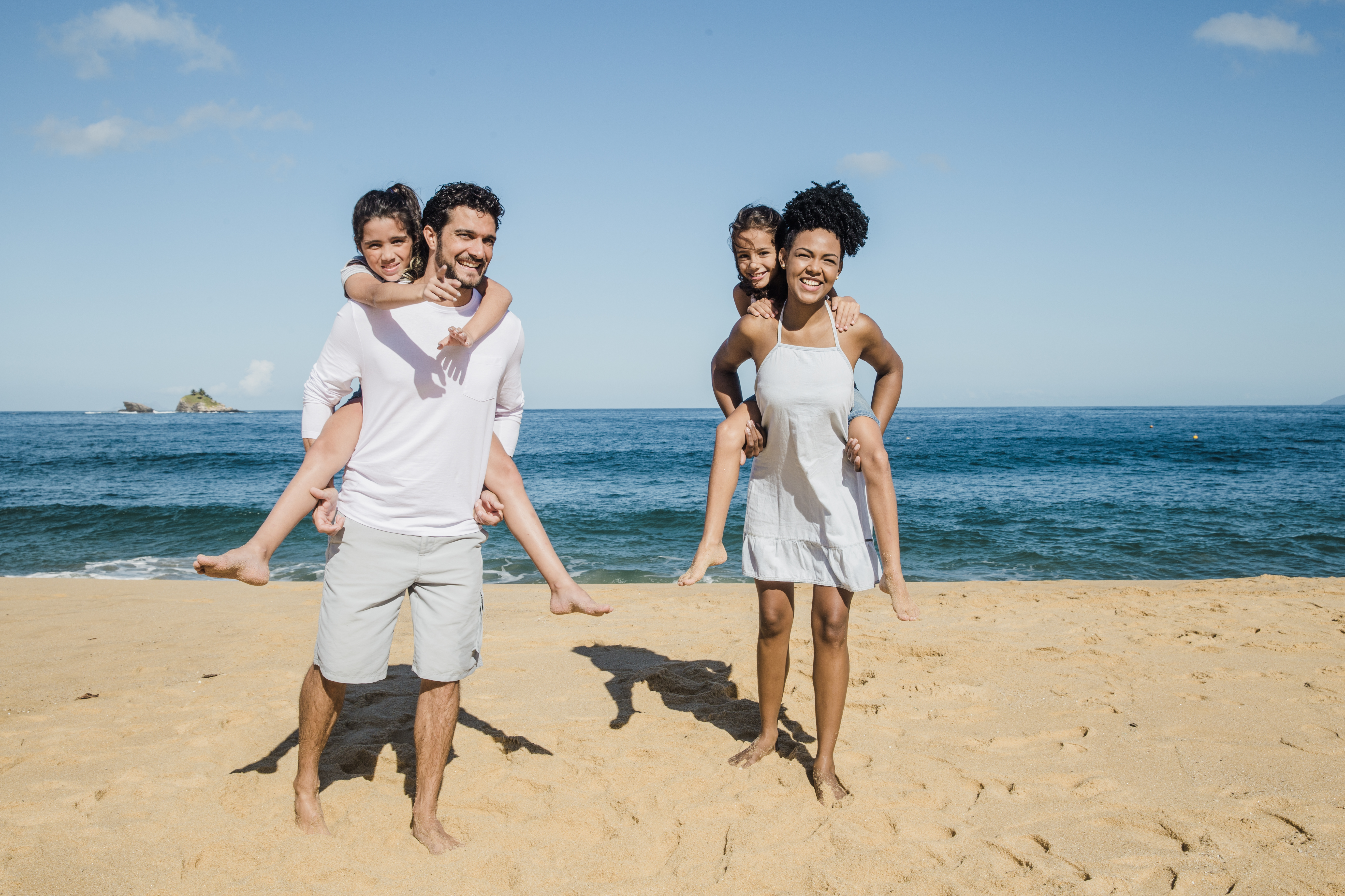 Mom, Dad, and their two children playing at the beach