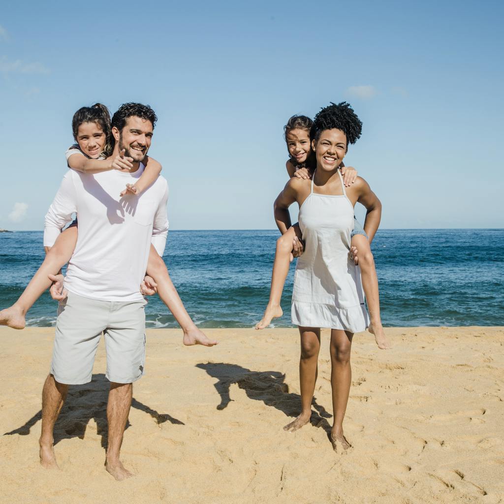Mom, Dad, and their two children playing at the beach